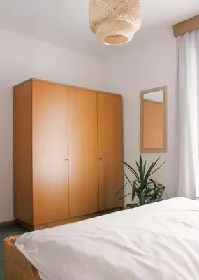 a bedroom with a large wooden cabinet and a bed at haus e Apartment 2 in Lana