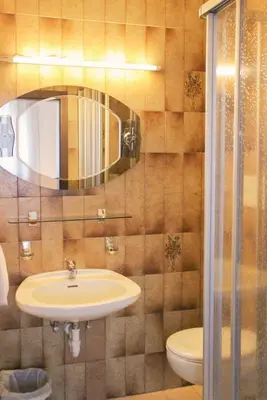 a bathroom with a sink and a toilet and a mirror at haus e Apartment 2 in Lana