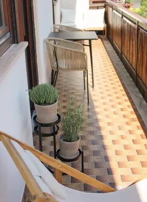 a balcony with two chairs and tables and plants at haus e Apartment 2 in Lana