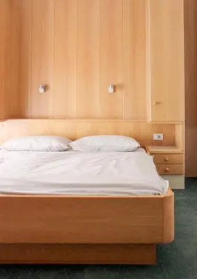a bed in a room with wooden cabinets at haus e Apartment 2 in Lana