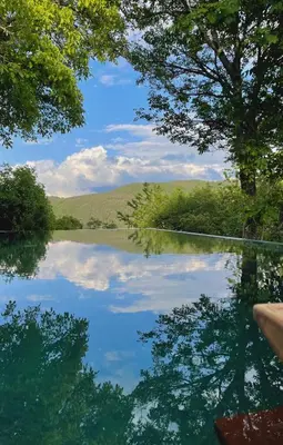 a view of a lake with trees and mountains in the background at Eden Apartment in Soprabolzano