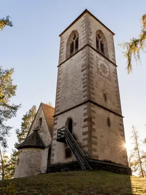 an old church with a tower with a clock on it at Eden Apartment in Soprabolzano