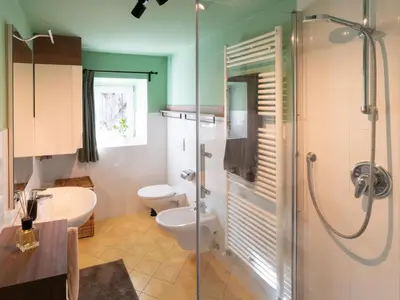 a bathroom with a shower and a toilet and a sink at Eden Apartment in Soprabolzano