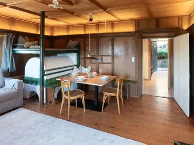 a room with a table and a bunk bed at Eden Apartment in Soprabolzano