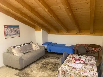 a living room with a couch and a bed at Lagorai Suites in Cavalese