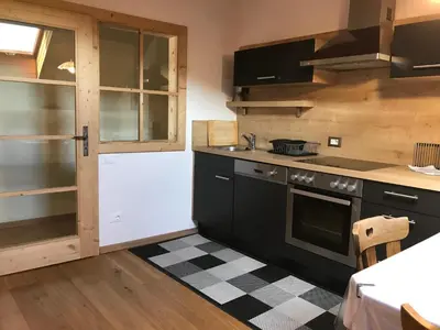 a kitchen with black cabinets and a stove at Platzerhof in Monguelfo