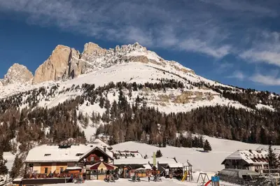 a ski lodge in front of a mountain at Bar-Restaurant-Pizzeria Antermont B&B in Carezza al Lago