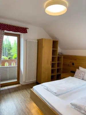 a bedroom with a bed and a large window at Bar-Restaurant-Pizzeria Antermont B&B in Carezza al Lago