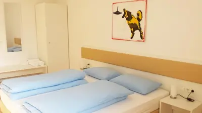 a room with two beds and a painting on the wall at Manzoni Rooms in Merano