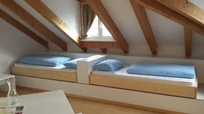 two beds in a room with a window at Manzoni Rooms in Merano