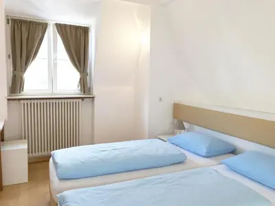 a bedroom with two beds and a window at Manzoni Rooms in Merano