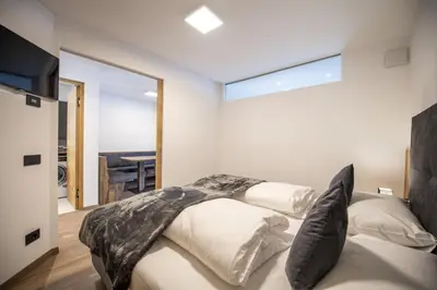 a bedroom with a bed with black and white pillows at Apartment Villa Hetty 2 in Ortisei