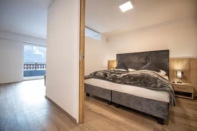 a bedroom with a large bed and a large window at Apartment Villa Hetty 2 in Ortisei