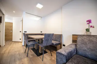 a dining room with a table and chairs and a couch at Apartment Villa Hetty 2 in Ortisei