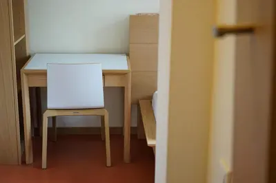 a small table with a chair and a white desk at Priesterseminar Brixen in Bressanone