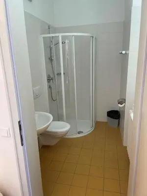 a bathroom with a shower and a toilet and a sink at Priesterseminar Brixen in Bressanone