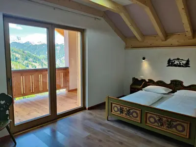 a bedroom with a bed and a large window at Freines in La Valle