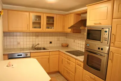 a kitchen with wooden cabinets and a stove top oven at Freines in La Valle