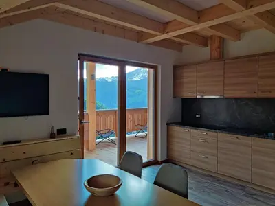 a dining room with a table and a television and a view at Freines in La Valle