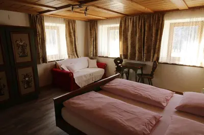 a bedroom with two beds and a couch and a chair at Freines in La Valle