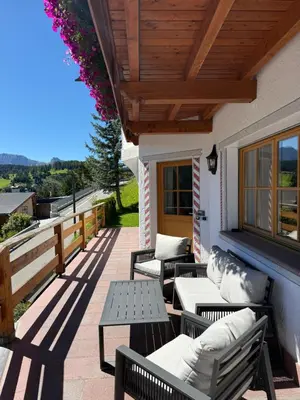 a patio with benches and tables on a house at La Funtana in Santa Cristina in Val Gardena