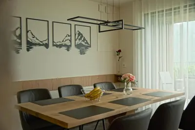 a dining room with a wooden table and chairs at Monte Sole Suite - mit Sauna & Garten in Perca