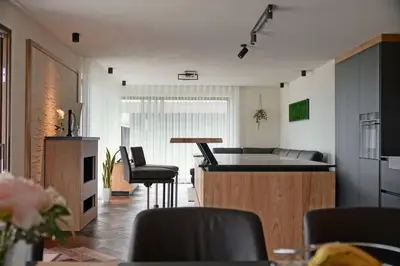 a kitchen and living room with a table and chairs at Monte Sole Suite - mit Sauna & Garten in Perca