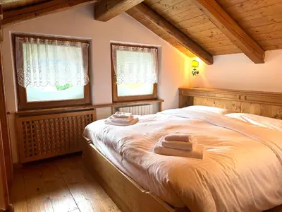 a bedroom with a bed with two towels on it at Appartamento ampezzano con ampia balconata in San Vito di Cadore