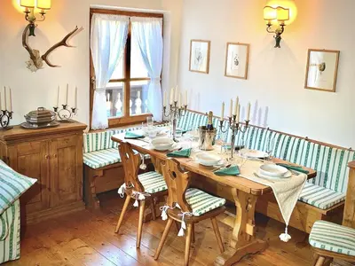 a dining room with a wooden table and chairs at Appartamento ampezzano con ampia balconata in San Vito di Cadore