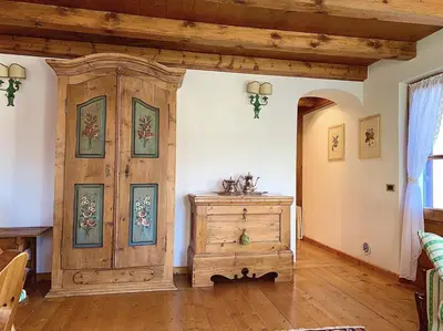 a room with a wooden cabinet and a wooden floor at Appartamento ampezzano con ampia balconata in San Vito di Cadore
