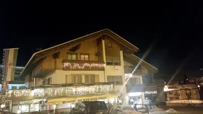 a building with christmas lights on it at night at Chalet Karin in Arabba