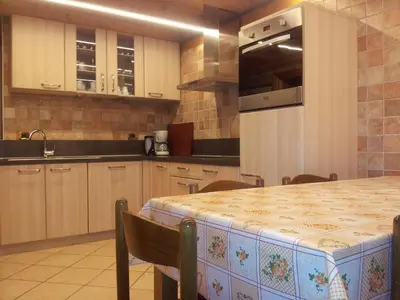 a large kitchen with a table and a counter top at Chalet Karin in Arabba