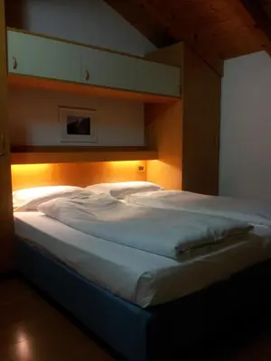 a bedroom with a large white bed with lights on it at Chalet Karin in Arabba