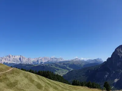 a grassy hill with mountains in the background at Chalet Karin in Arabba