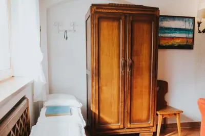a bedroom with a wooden cabinet next to a bed at Casa Aurine di Zaccaria in Frassenè