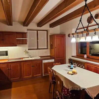 a kitchen with a table with chairs and a tableablish at Casa Aurine di Zaccaria in Frassenè