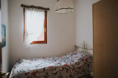 a bedroom with a bed and a window at Casa Aurine di Zaccaria in Frassenè
