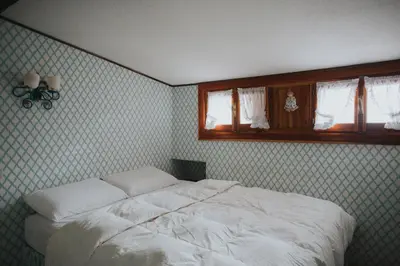 a bedroom with a white bed and a window at Casa Aurine di Zaccaria in Frassenè