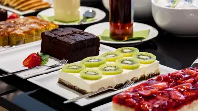 a table topped with a plate of cake and fruit at Flora Hotel & Suites in Merano