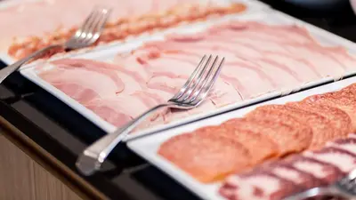 two plates of food with forks on a table at Flora Hotel & Suites in Merano