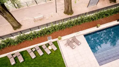an overhead view of a swimming pool with lounge chairs at Flora Hotel & Suites in Merano
