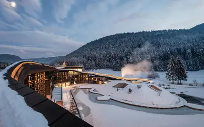 a ski resort in the snow with snow covered ground at Falkensteiner Family Resort Lido l 4 Star Superior in Chienes