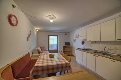 a kitchen with a table and a dining room at Cèsa Al Bosch in Alba di Canazei