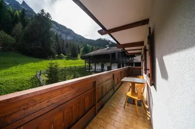 a balcony with a view of a house at Cèsa Al Bosch in Alba di Canazei