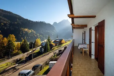 a balcony with a view of a train track at Cèsa Al Bosch in Alba di Canazei