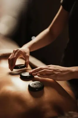 a woman reaching for a remote control on a table at Hotel Recort - Adults Only in Colfosco