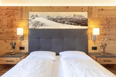a bedroom with two beds and a painting on the wall at Apartments La Mana in Santa Cristina in Val Gardena