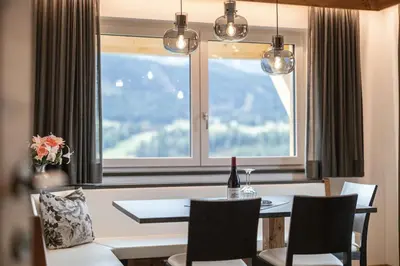 a dining room with a table and a large window at Apartments La Mana in Santa Cristina in Val Gardena