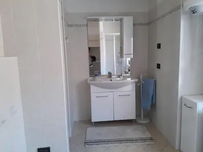 a white bathroom with a sink and a mirror at La cà di nonna Natalia in Brusago