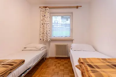 two beds in a room with a window at Casa Cielo Azzurro in Moena